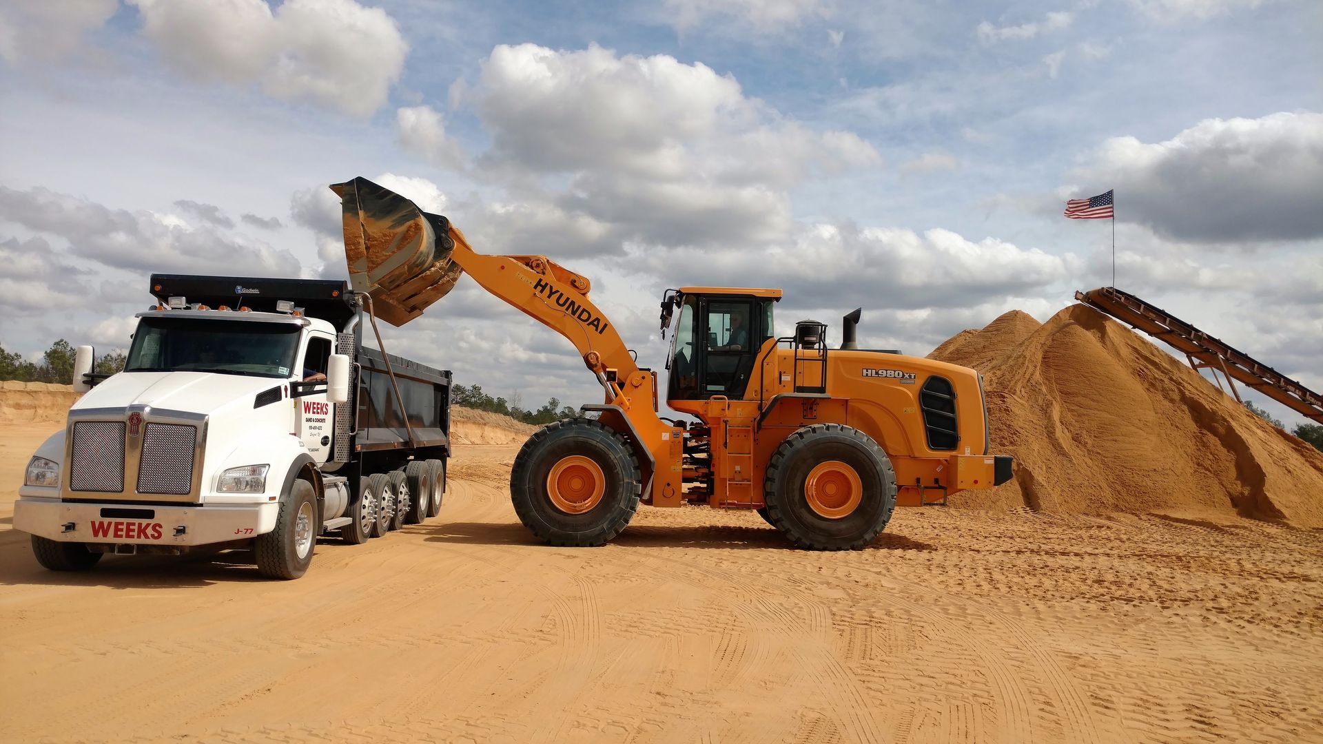 Front End Loader Dumping Sand into a Dumptruck