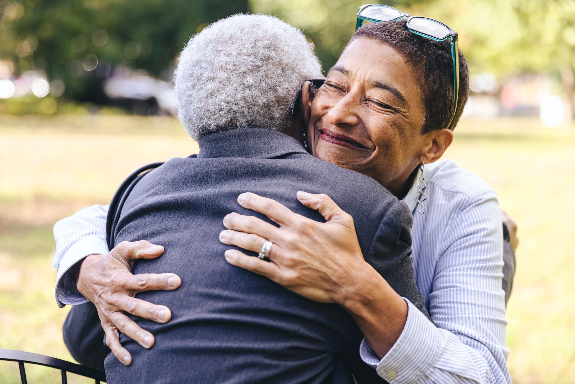 Smiling woman hugs her elderly mother.