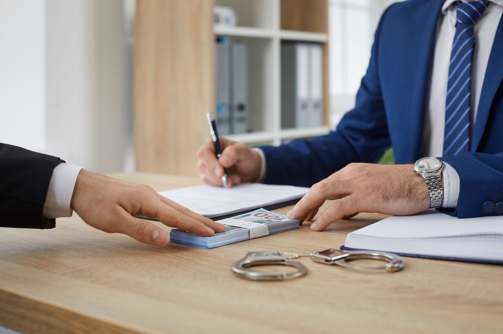 Bail bonds agent reviewing paperwork and cash payment during a client office meeting.
