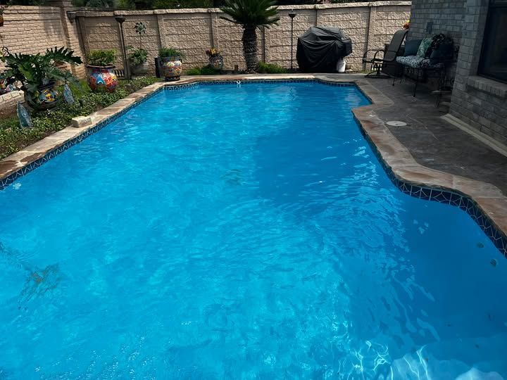 A large swimming pool in the backyard of a house.
