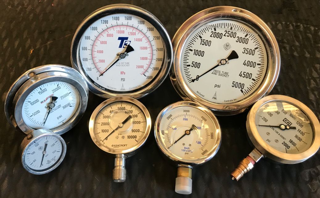 a group of pressure gauges are lined up on a table
