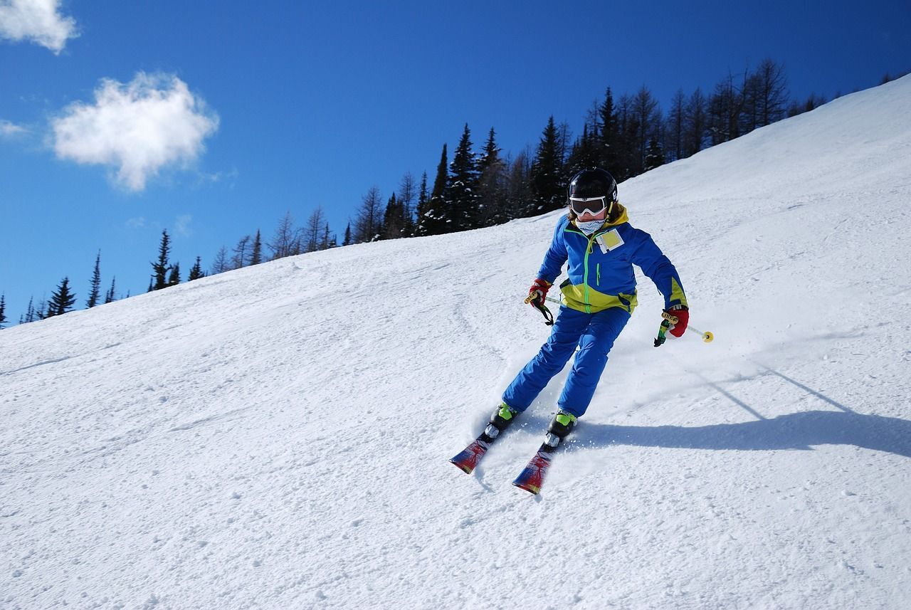 A person is skiing down a snow covered slope.
