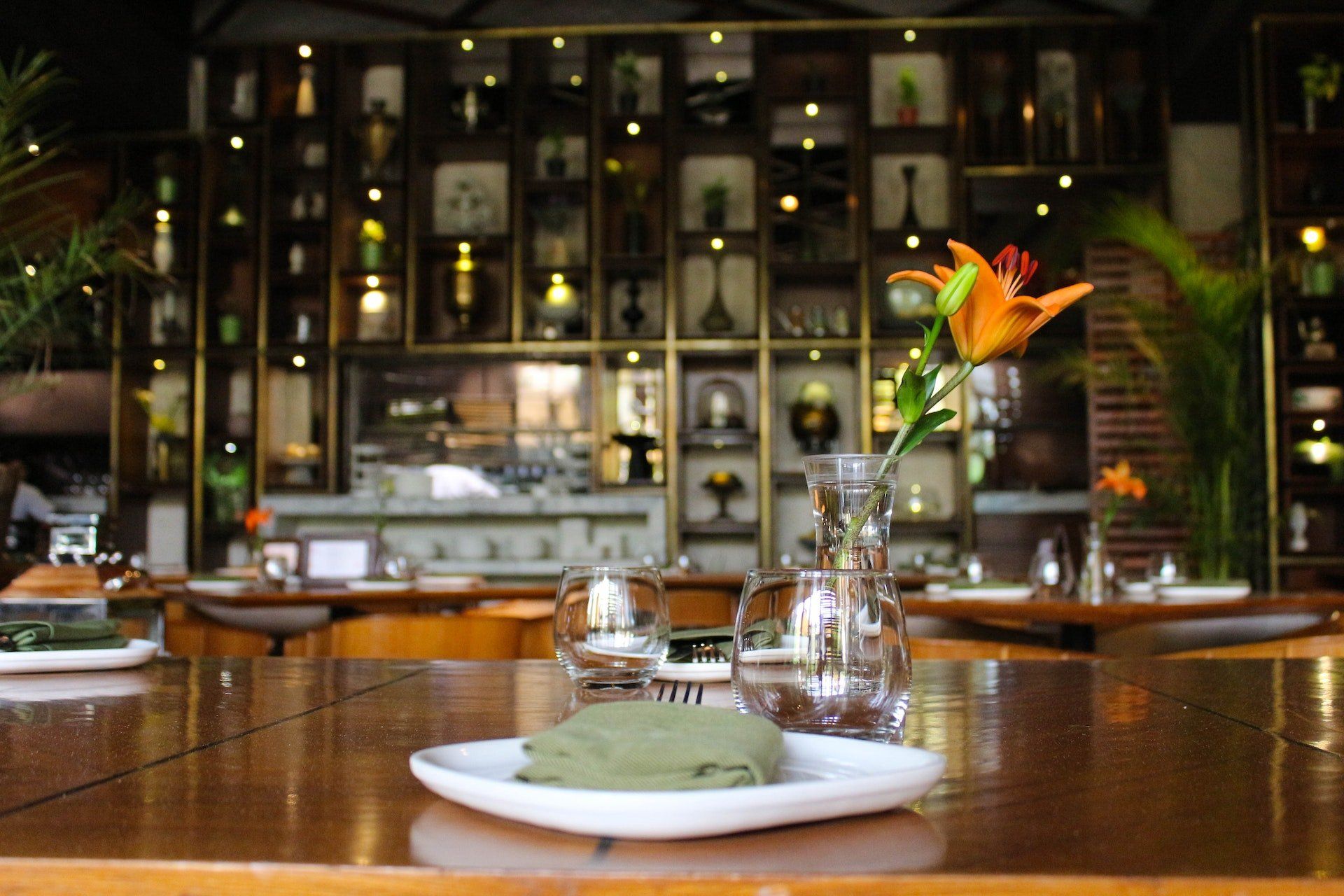 A table in a restaurant with a vase of flowers on it.