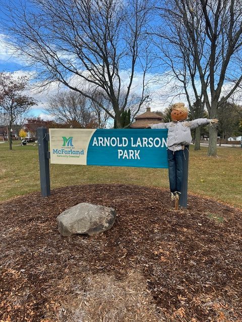 A group of people are sitting on the grass in a park.