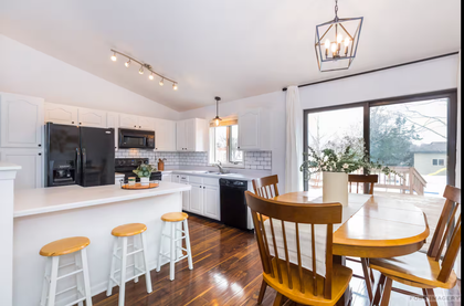 A kitchen with a table and chairs and a sliding glass door.