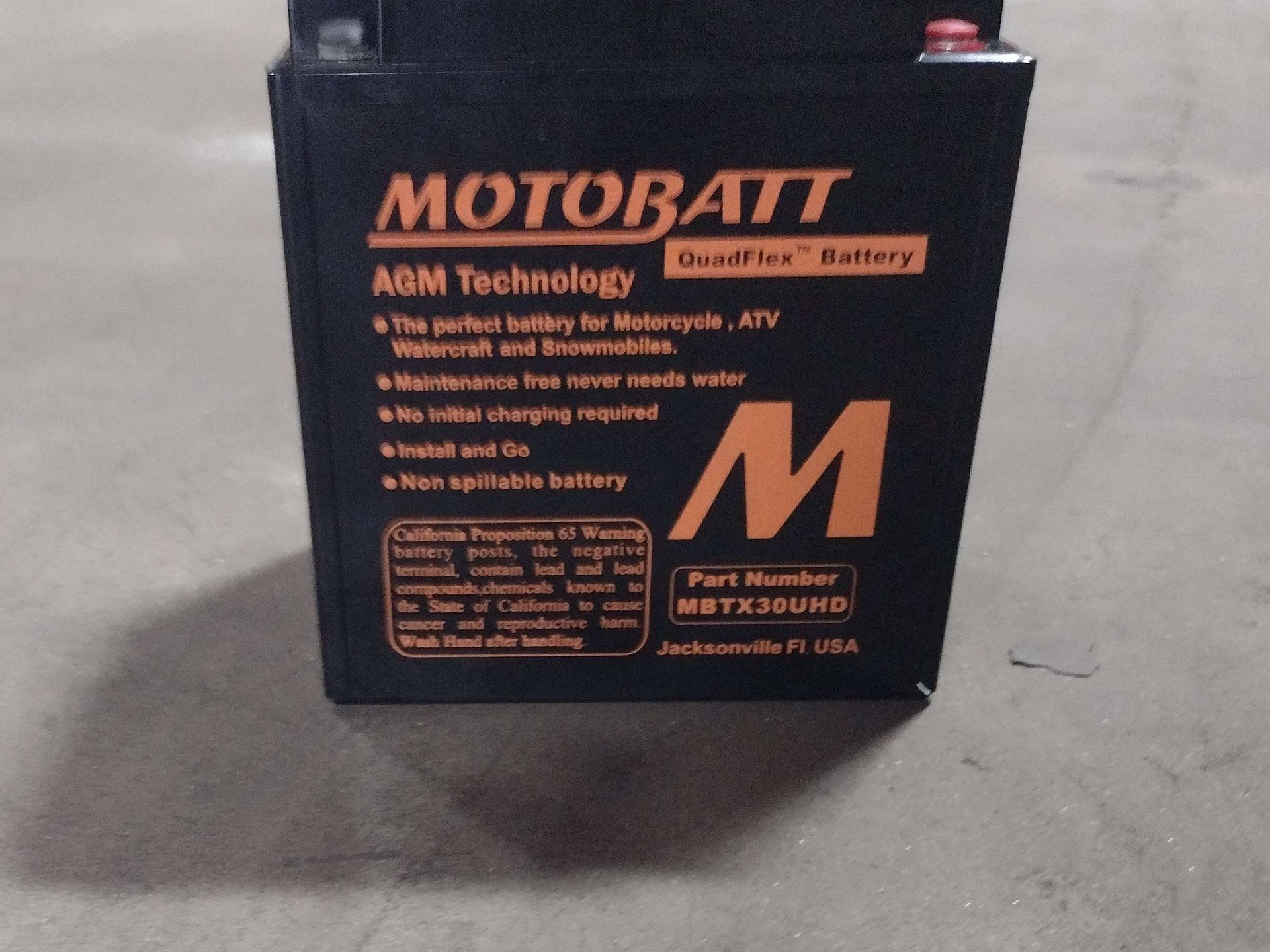 Black Motobatt motorcycle battery with orange lettering and 