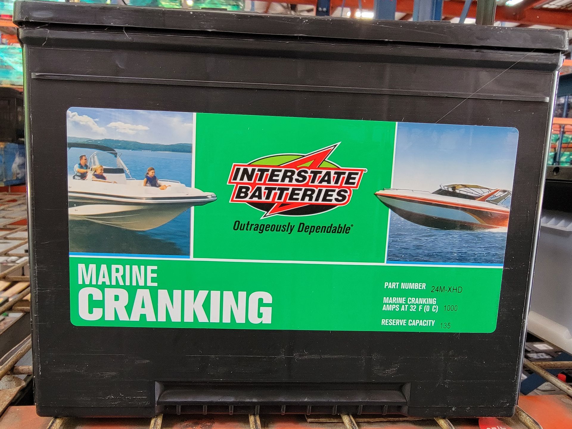 Black Interstate marine cranking battery with boats pictured.
