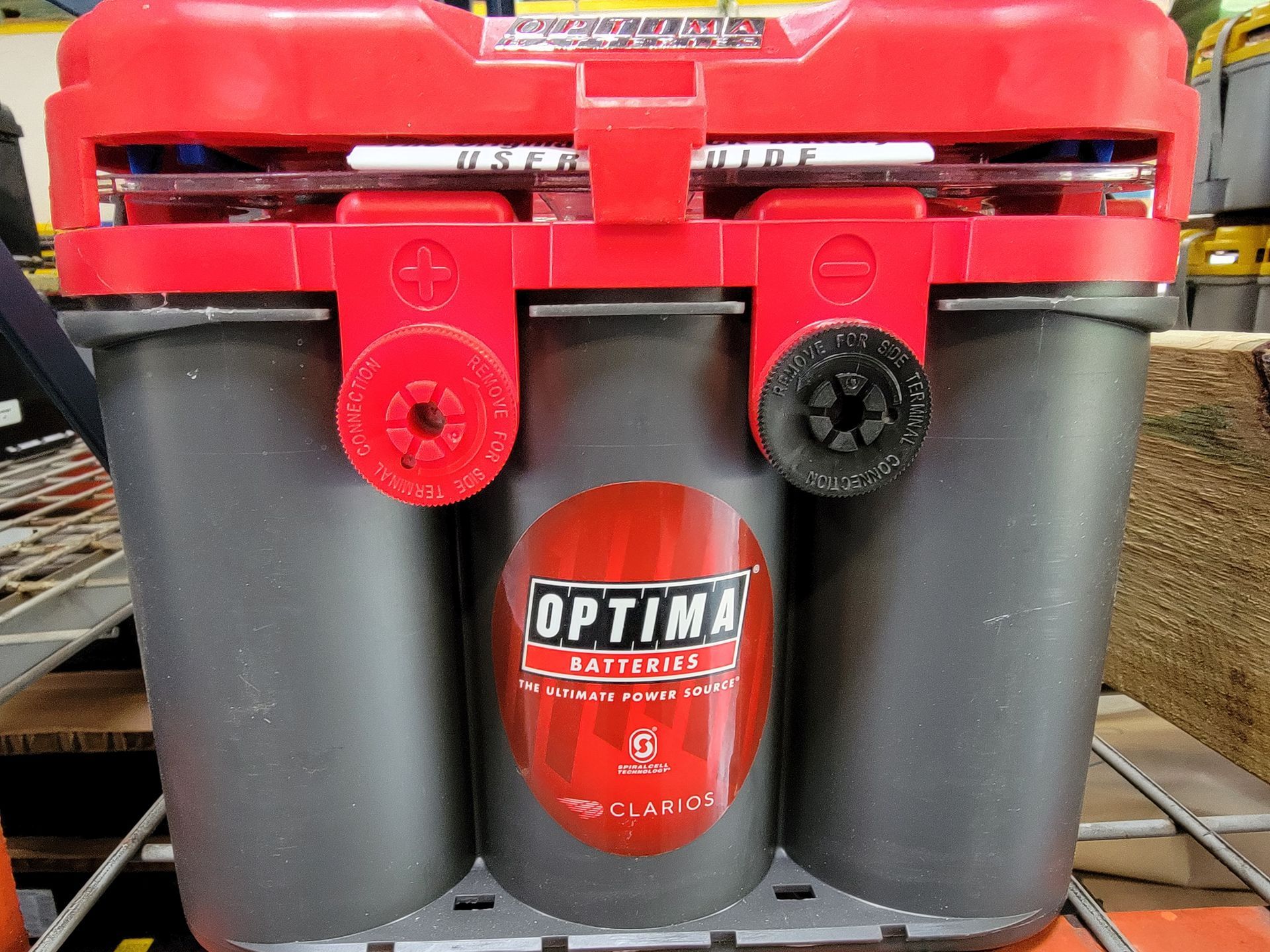 An Optima battery with red and gray components. The battery has a red top with terminals and the Optima Batteries logo.
