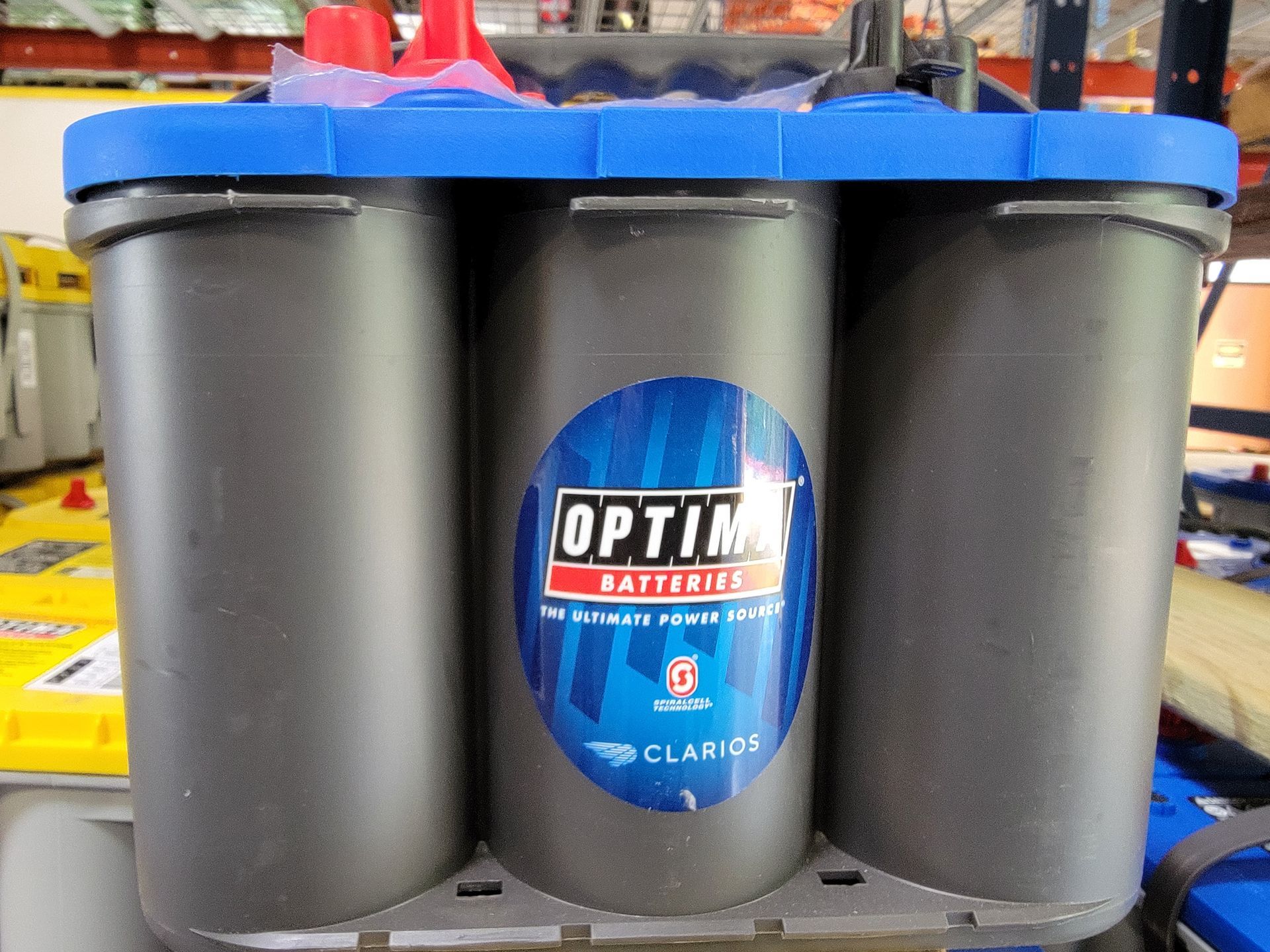 Optima CL4105 battery in blue and gray, with red caps, indoors.