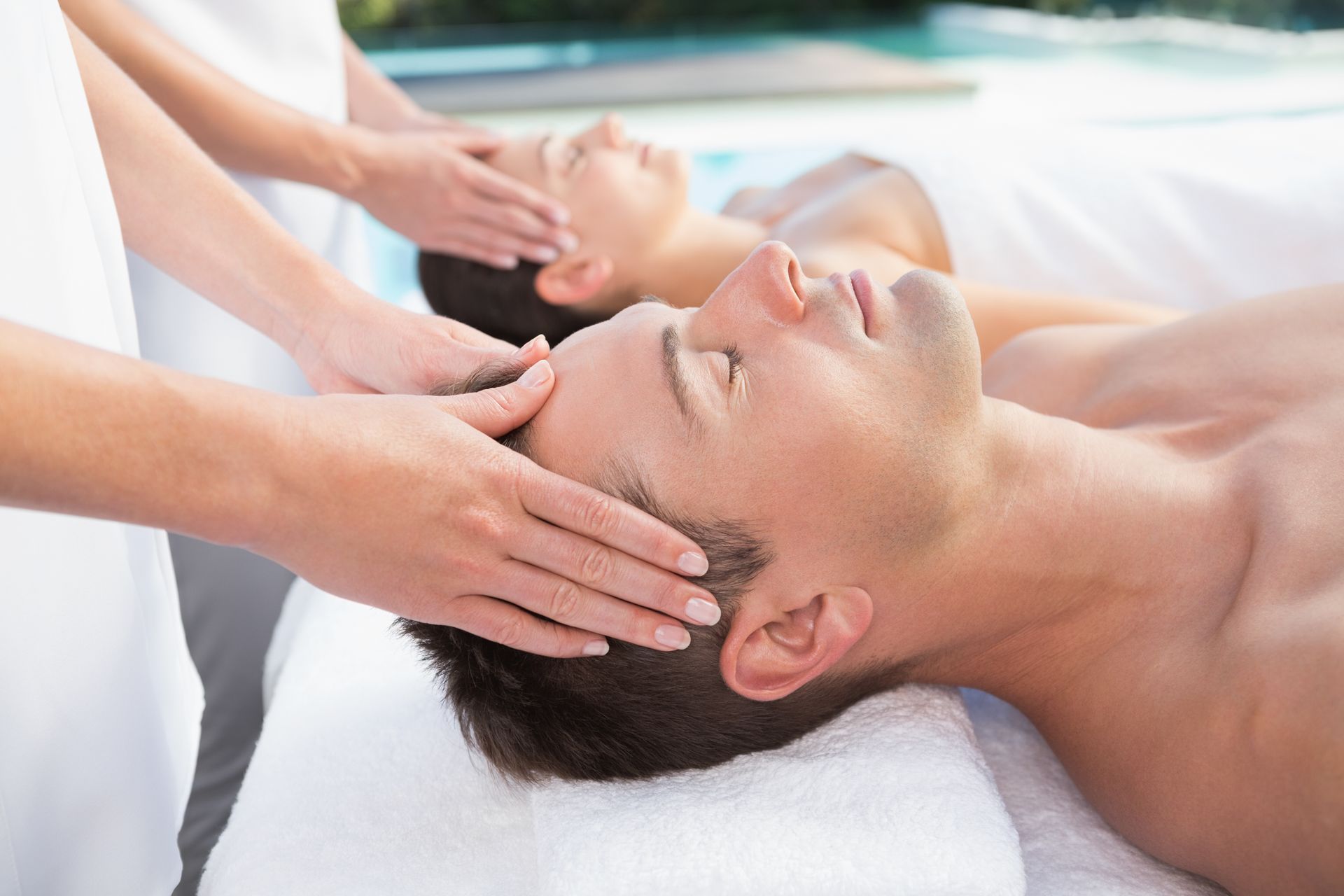 Two men are getting a head massage at a spa.