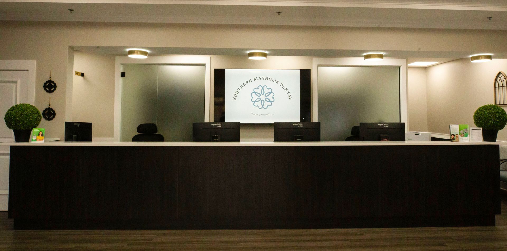 Southern Magnolia Dental logo in white on a blue background; a floral design and tagline.