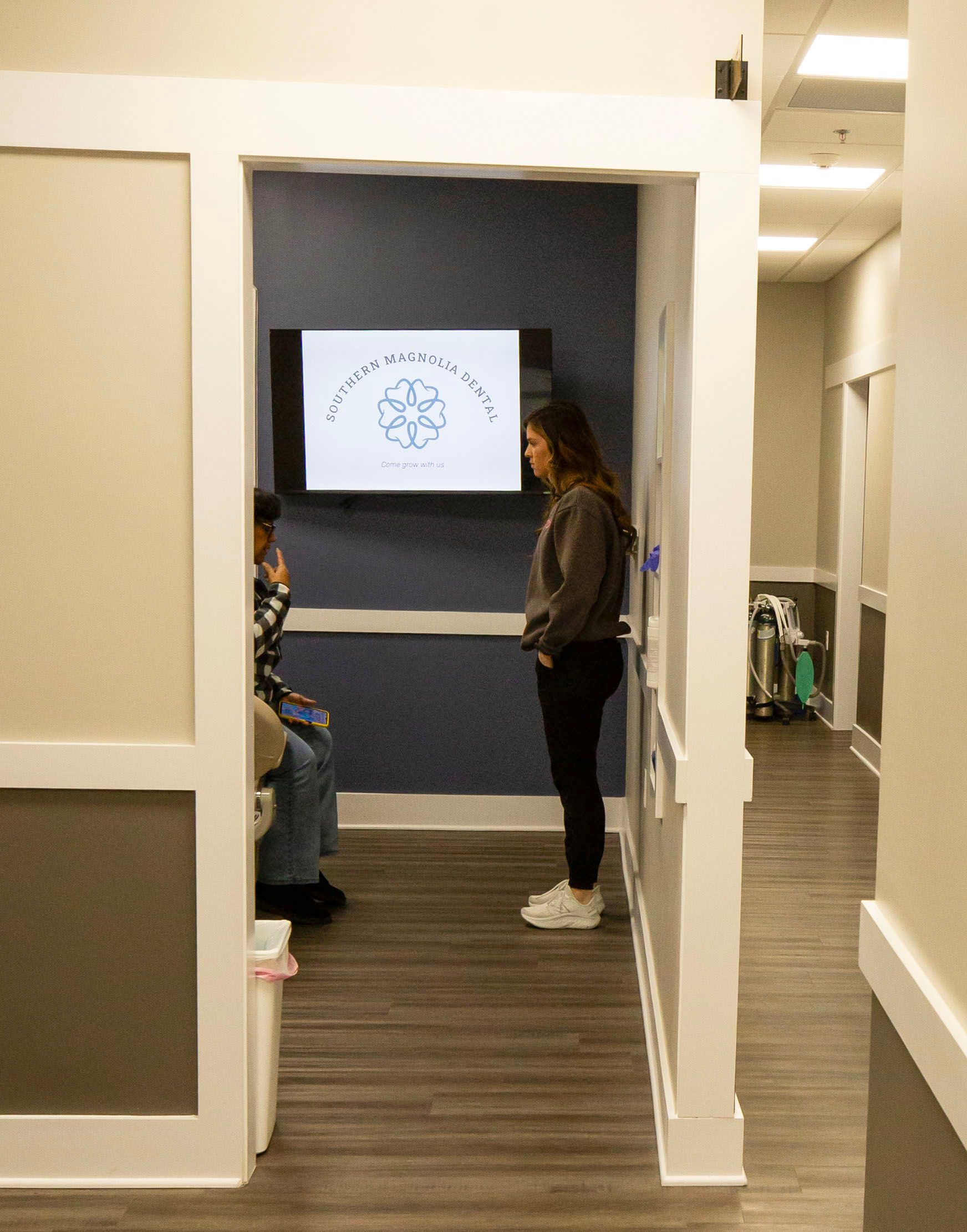 Southern Magnolia Dental logo in white on a blue background; a floral design and tagline.