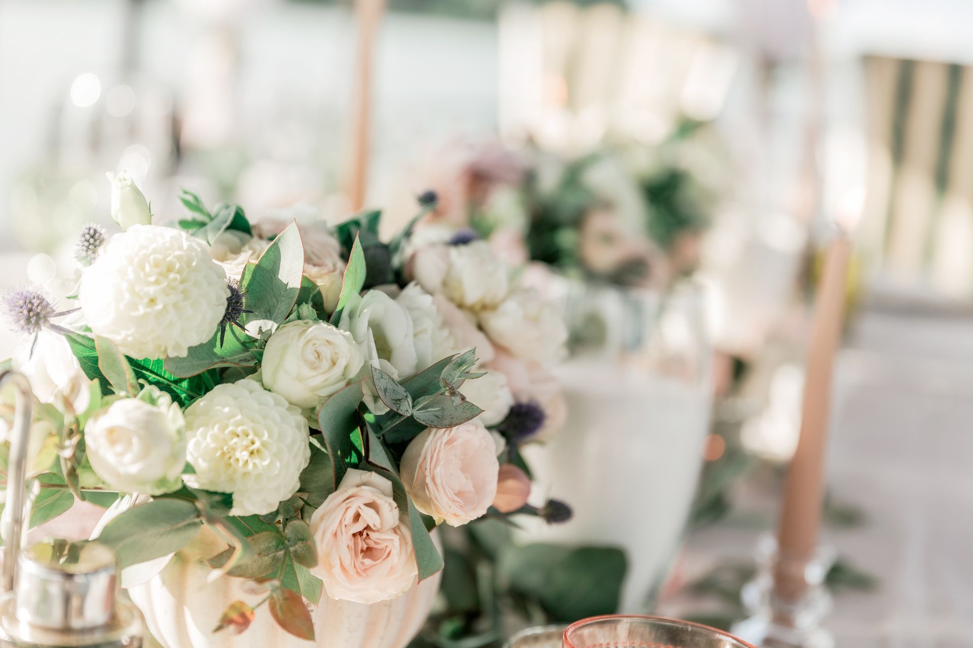 A vase filled with white flowers is on a table.