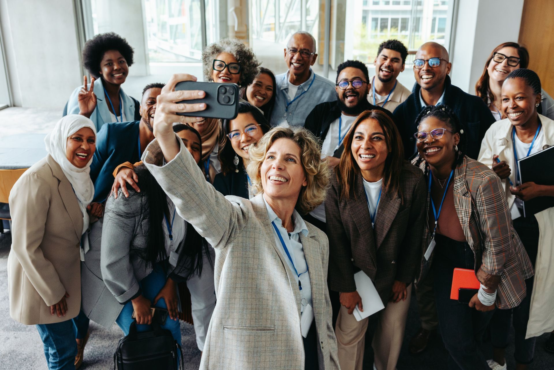 A woman is taking a selfie with a group of people.