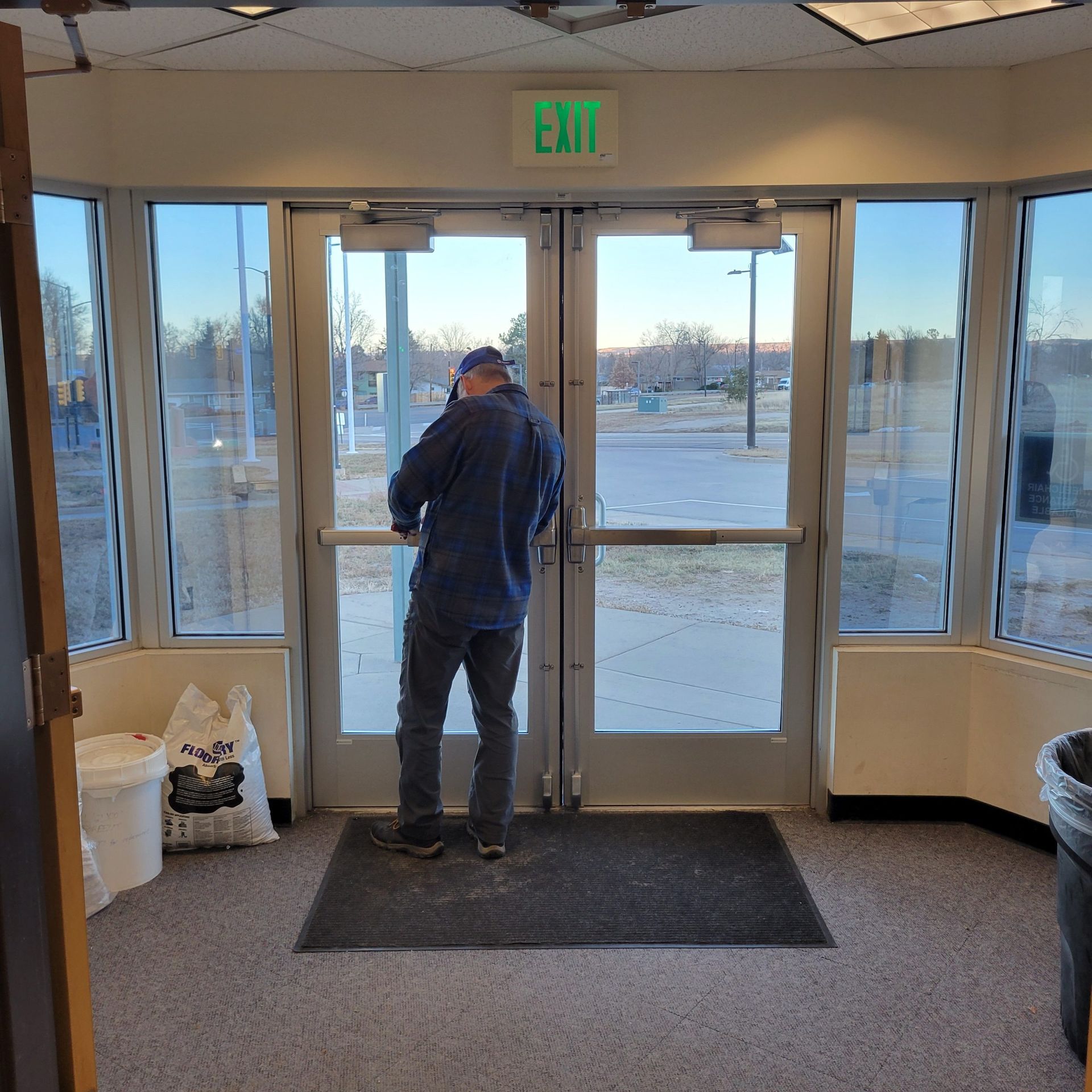 Man opening glass doors marked 