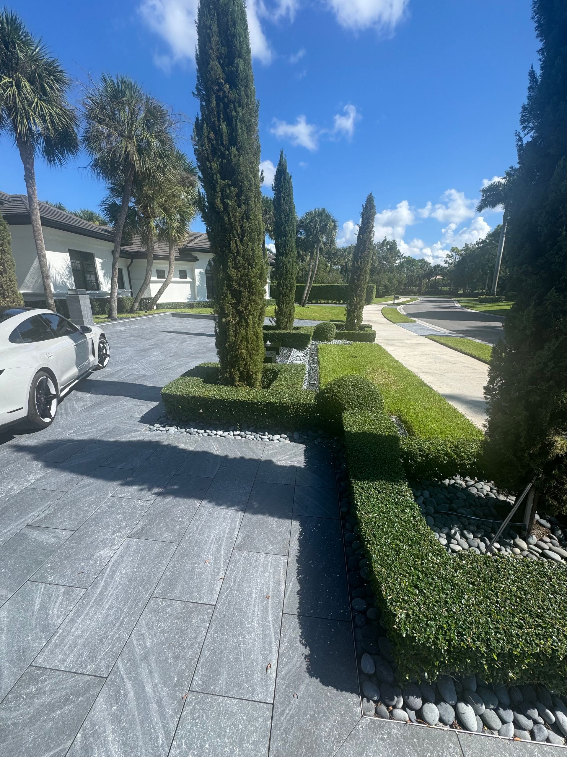 A white car is parked in the driveway of a house.