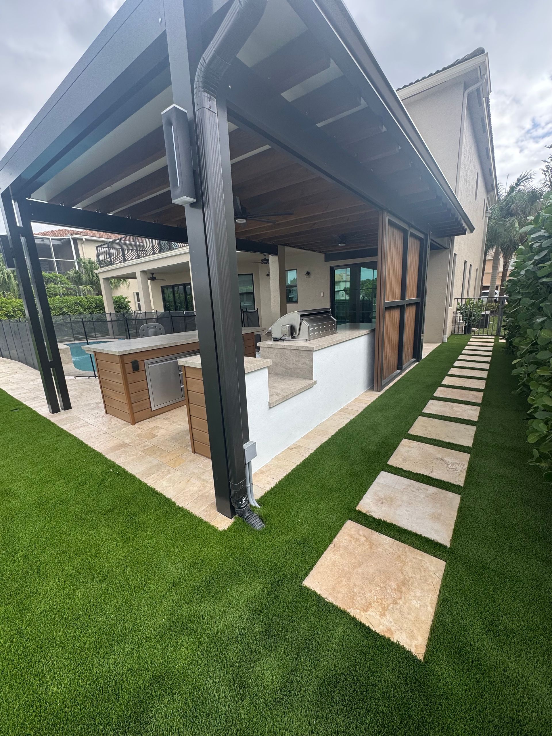 A house with a covered patio and a walkway leading to it.