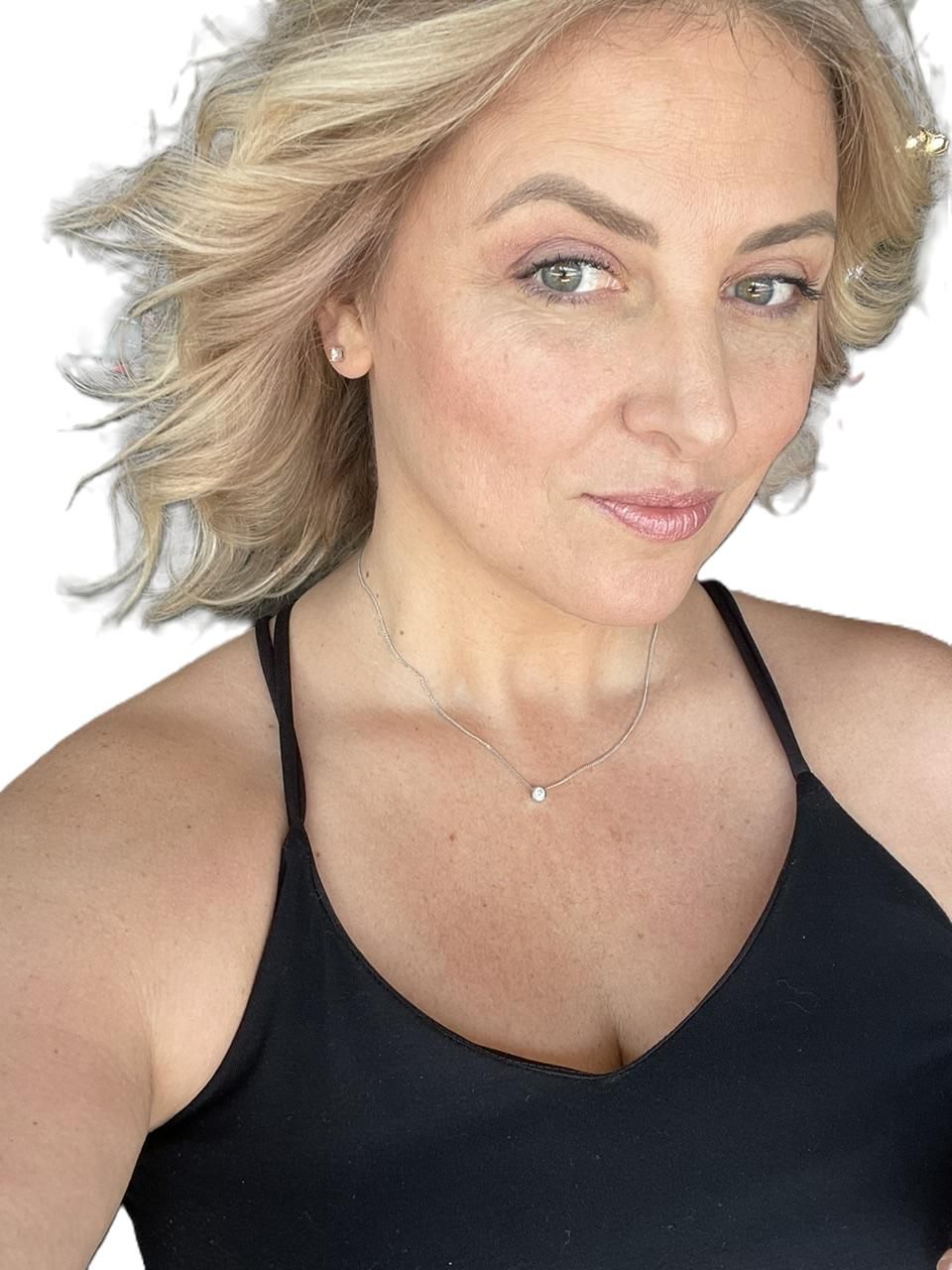 Woman with blonde hair wearing a black tank top, looking at the camera.