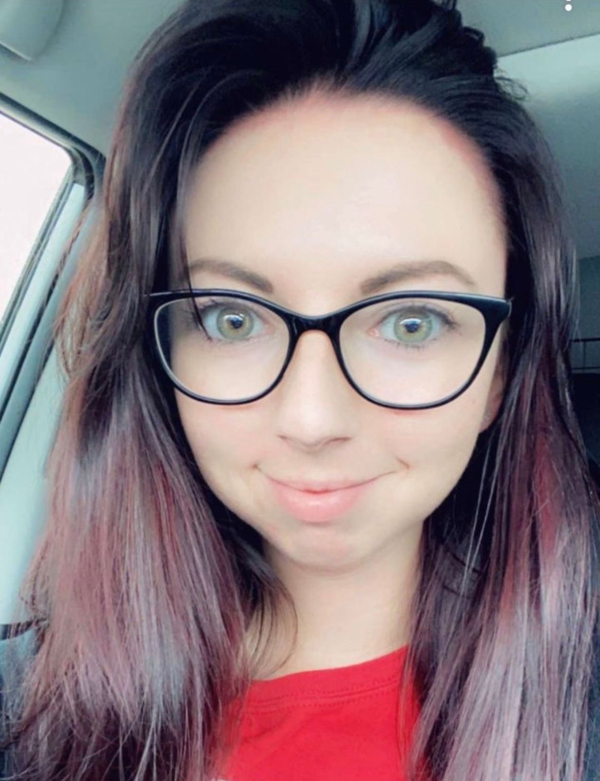 Woman with glasses, purple-ombre hair, red shirt, smiling.