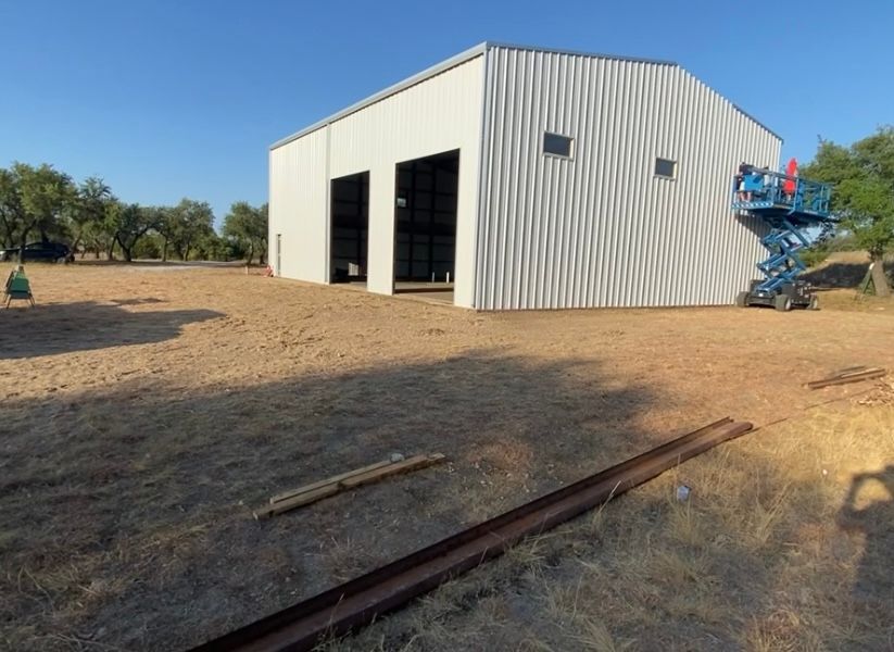 A large white building with a scissor lift in front of it.