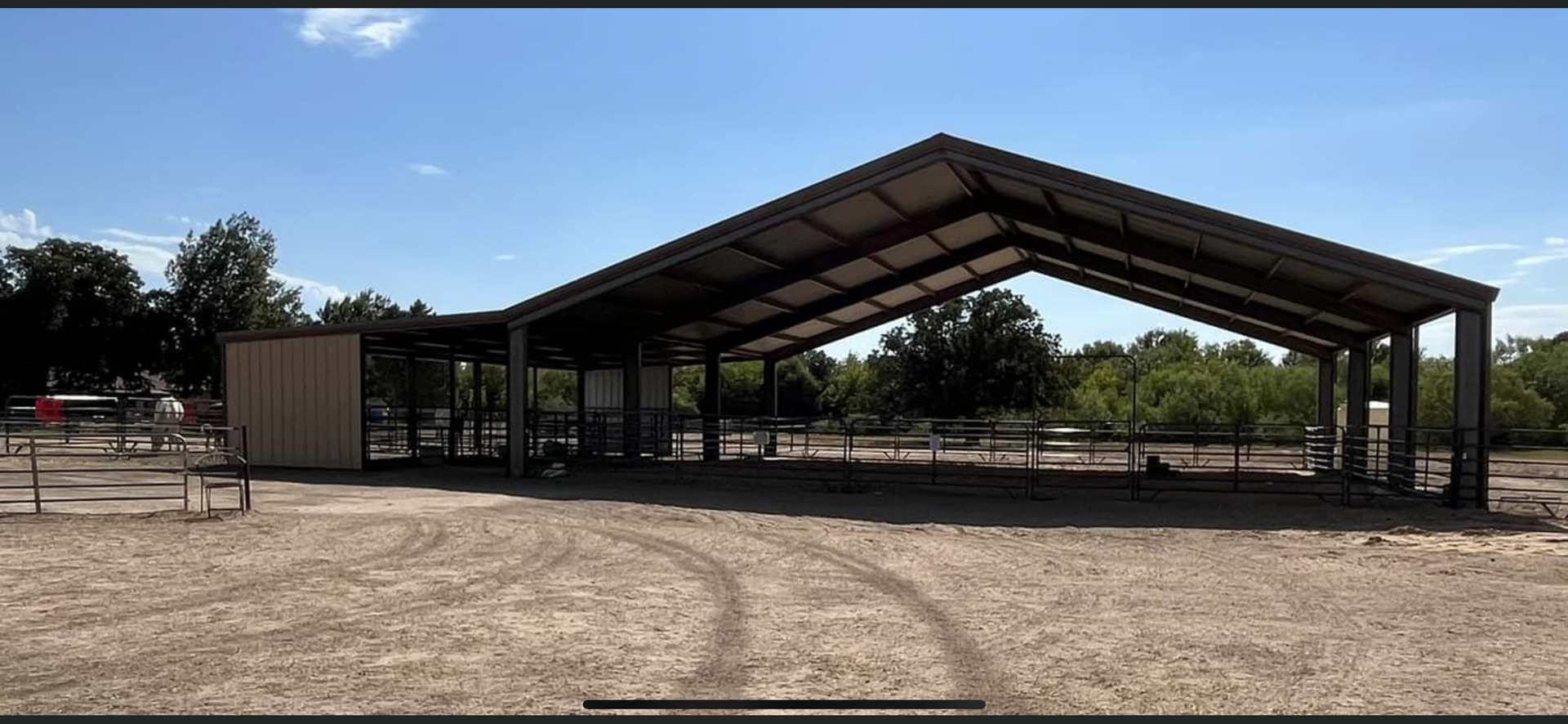 There is a large building in the middle of a dirt field.