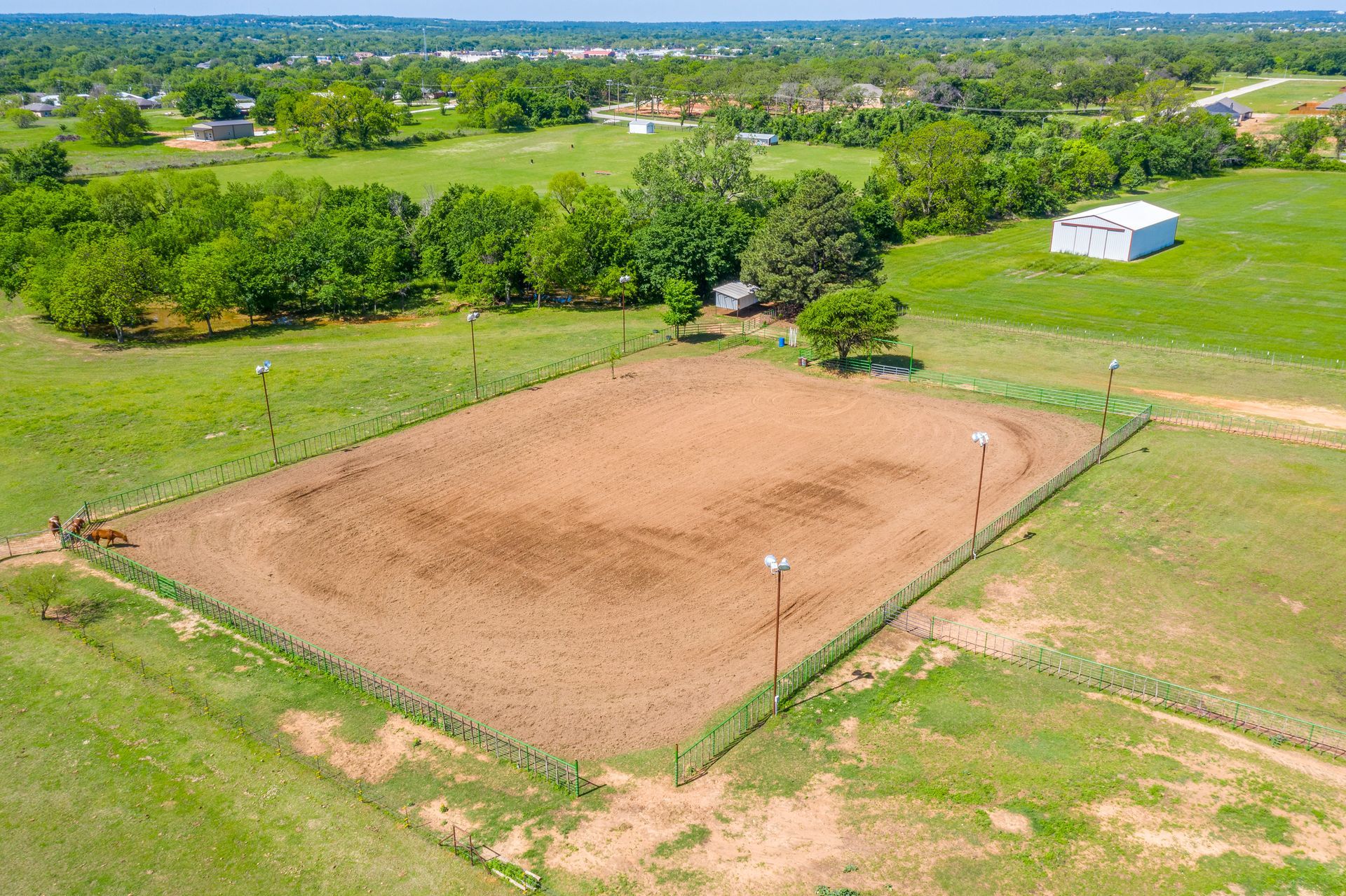 An aerial view of a dirt field with a fence around it.
