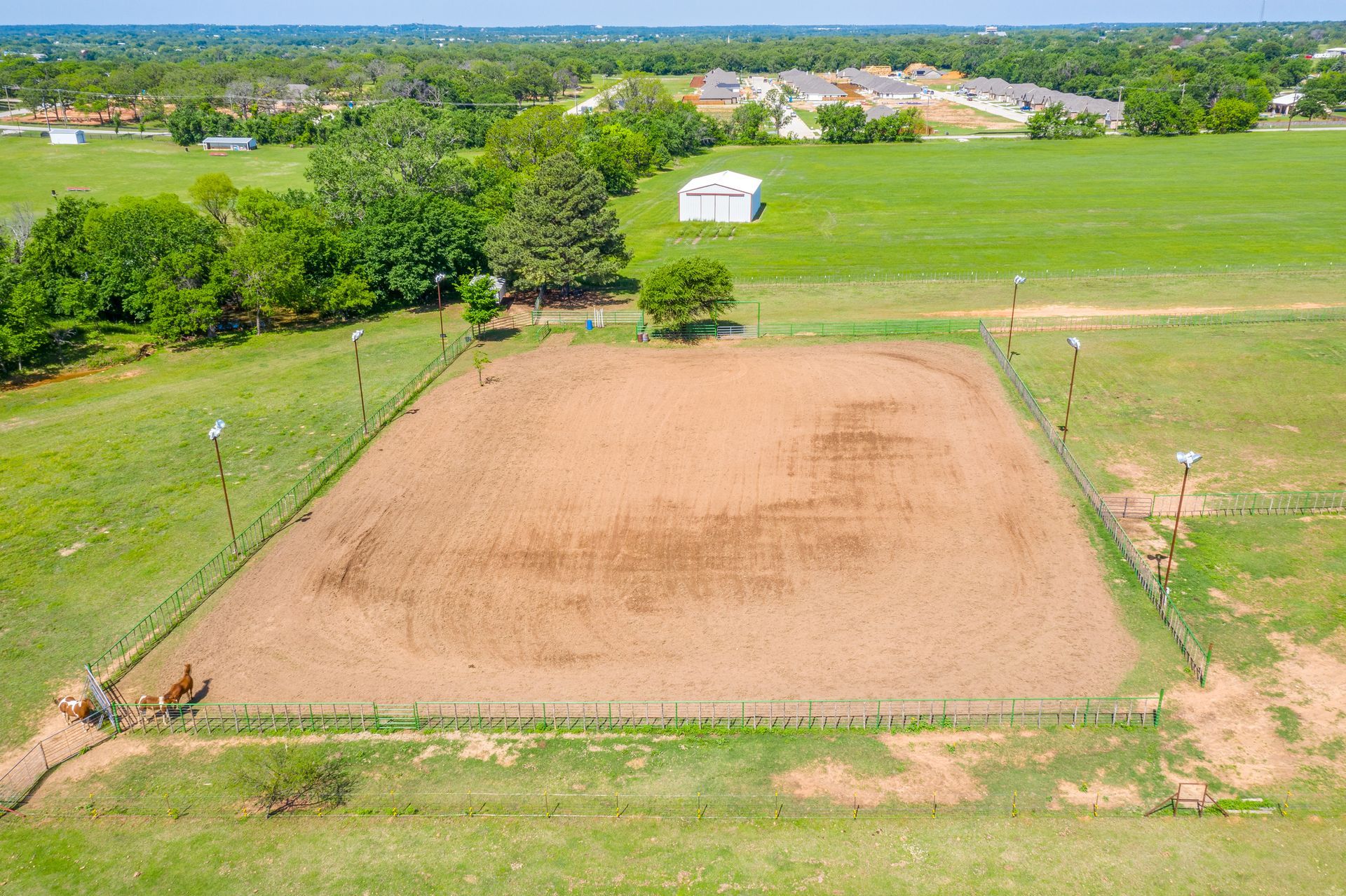 An aerial view of a dirt field with a fence around it.