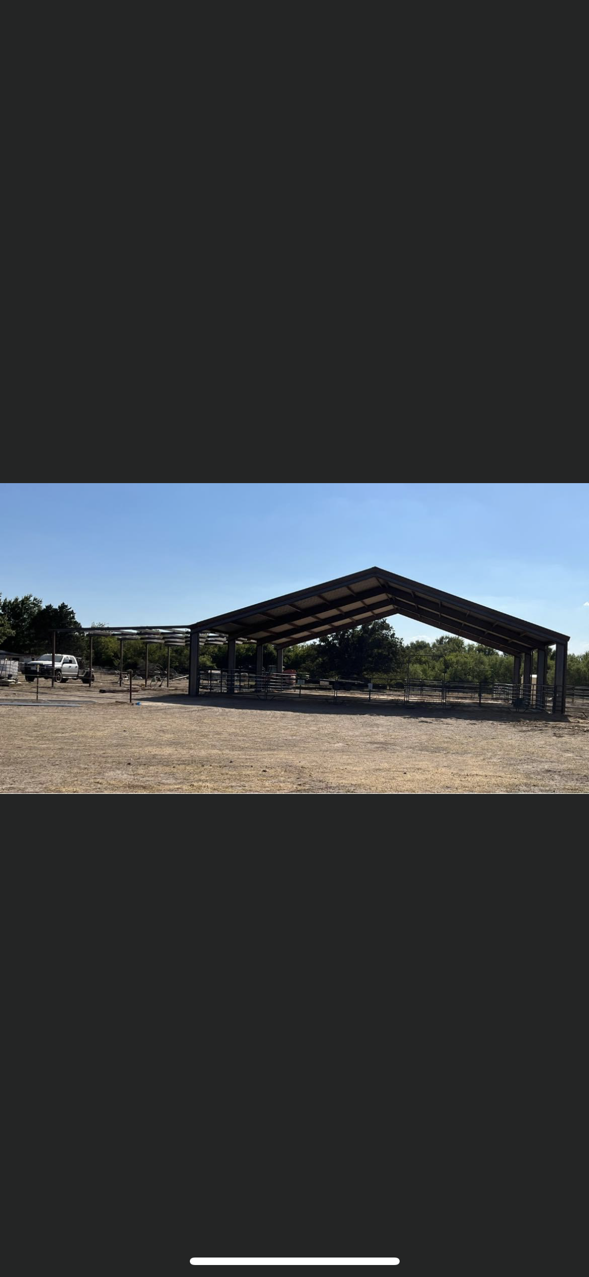 A large shed is sitting in the middle of a field.