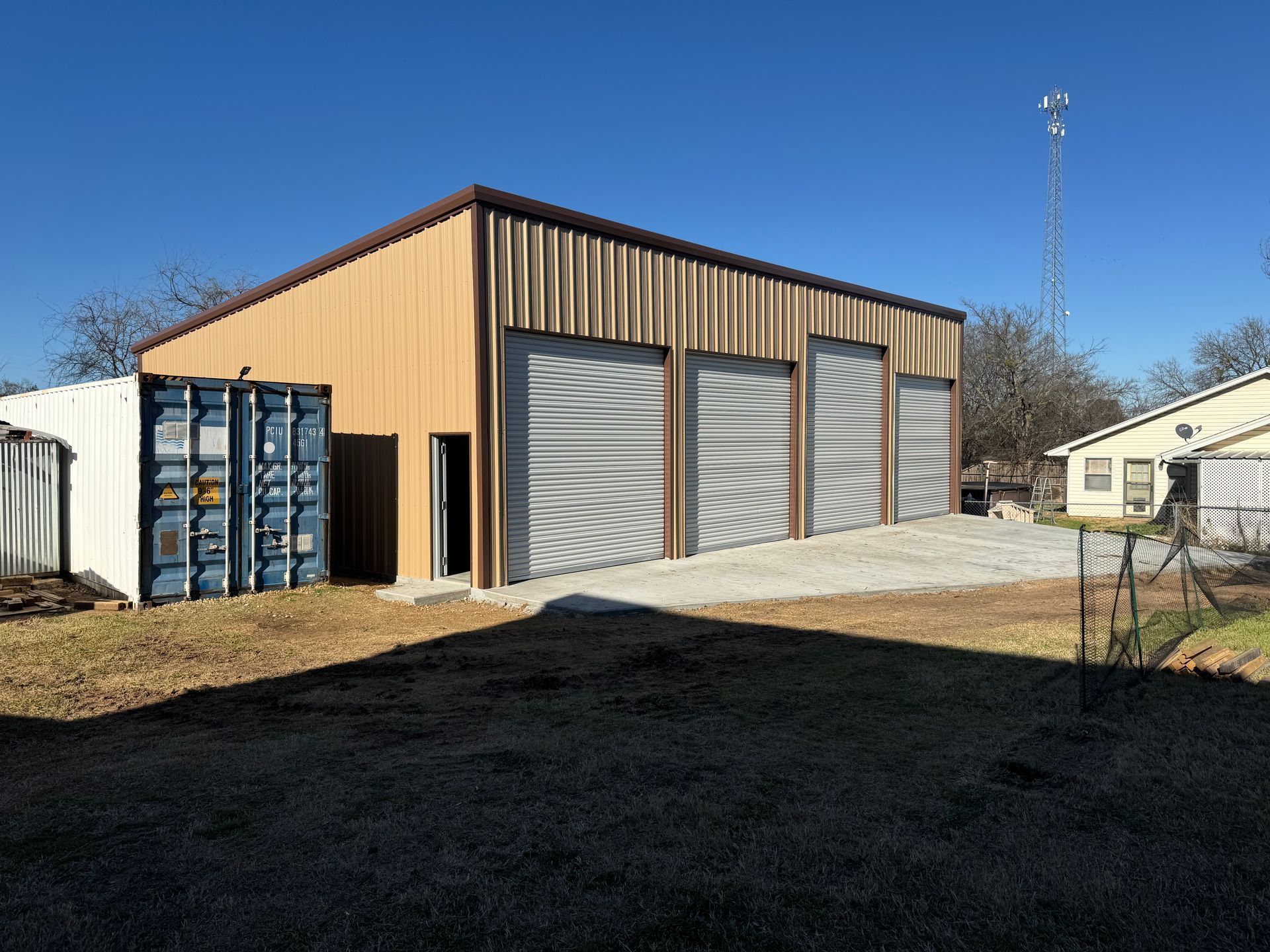 A large building with a lot of garage doors and a container in front of it.
