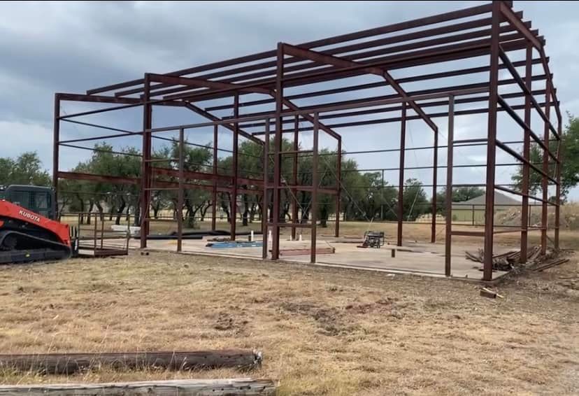 A large metal structure is being built in a field.
