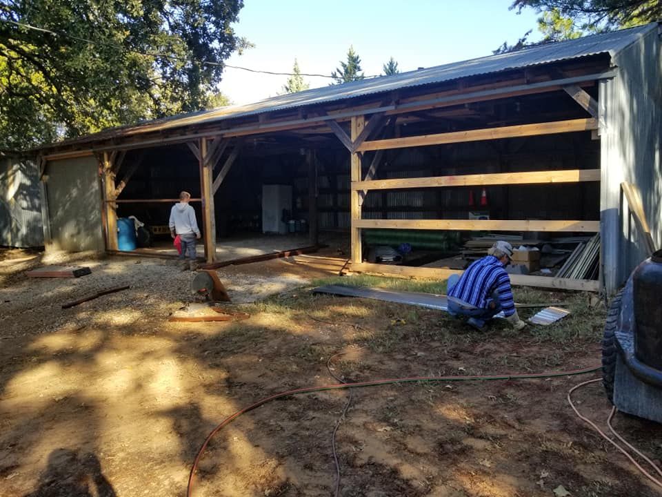 A man is kneeling in front of a building that is being built.