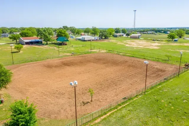 An aerial view of a dirt field with a fence around it.