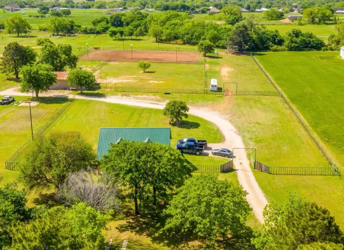 A man is standing on a ladder working on a greenhouse.