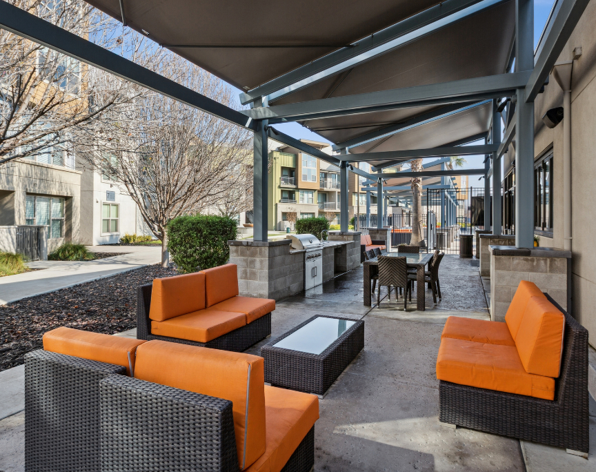 Outdoor seating area with grilling station at Aspire Apartments. 