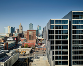 City skyline with modern buildings under a clear blue sky, viewed from above a downtown street