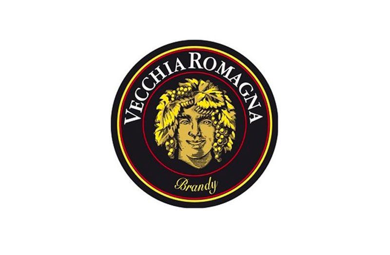 Logo del Brandy Vecchia Romagna: stemma circolare con quadrante dorato circondato da uva e testo.