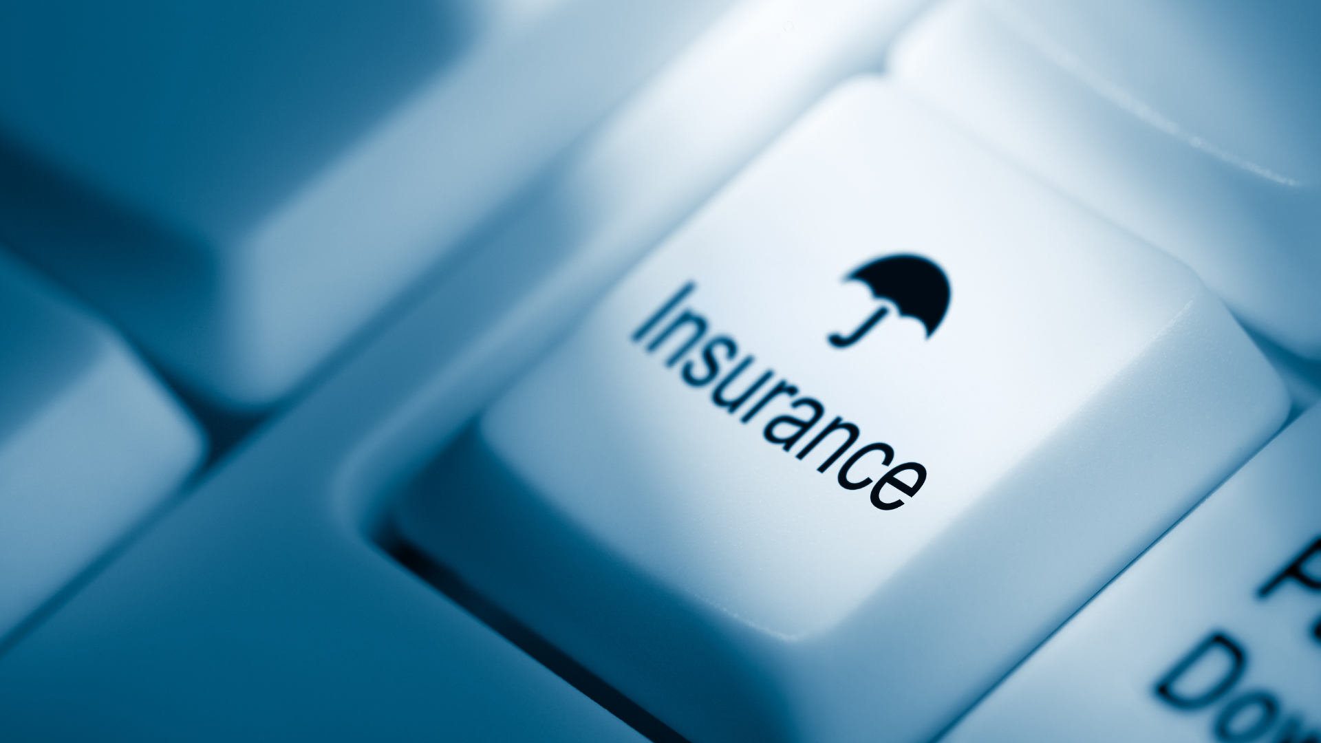 Close-up of a computer keyboard key with the word 'Insurance' and an umbrella icon, symbolizing insurance services.