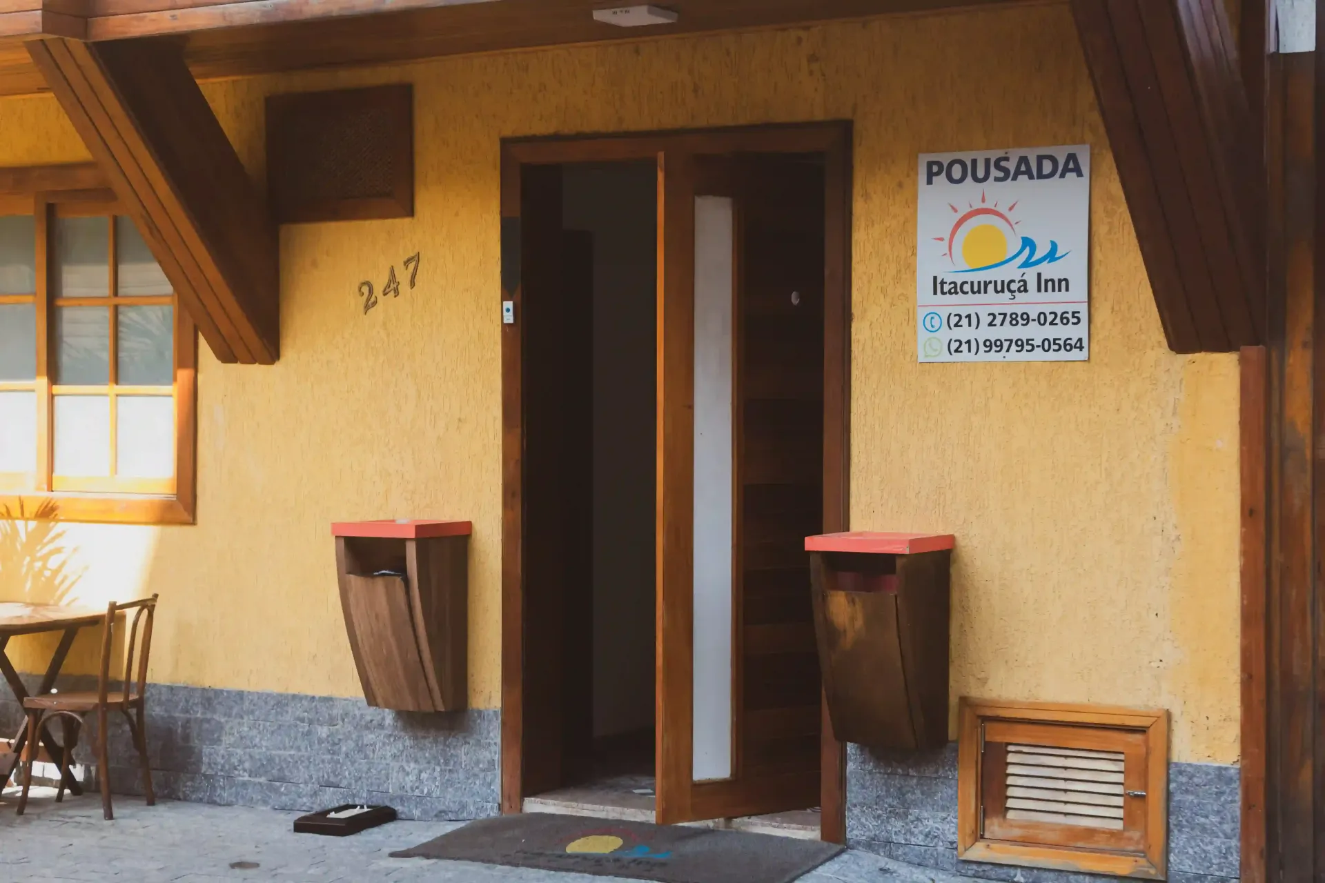 Um prédio amarelo com uma placa que diz pousada-pousada-itacuruca-inn