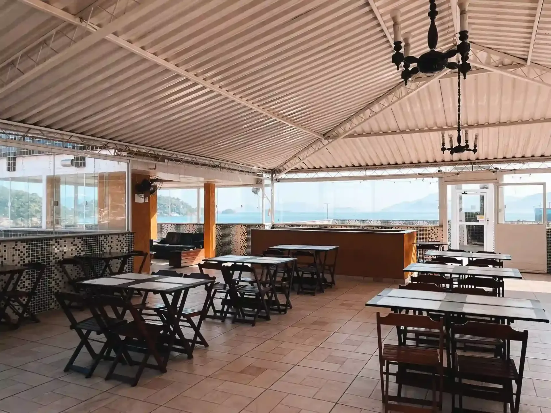 Há muitas mesas e cadeiras na sala.-pousada-itacuruca-inn