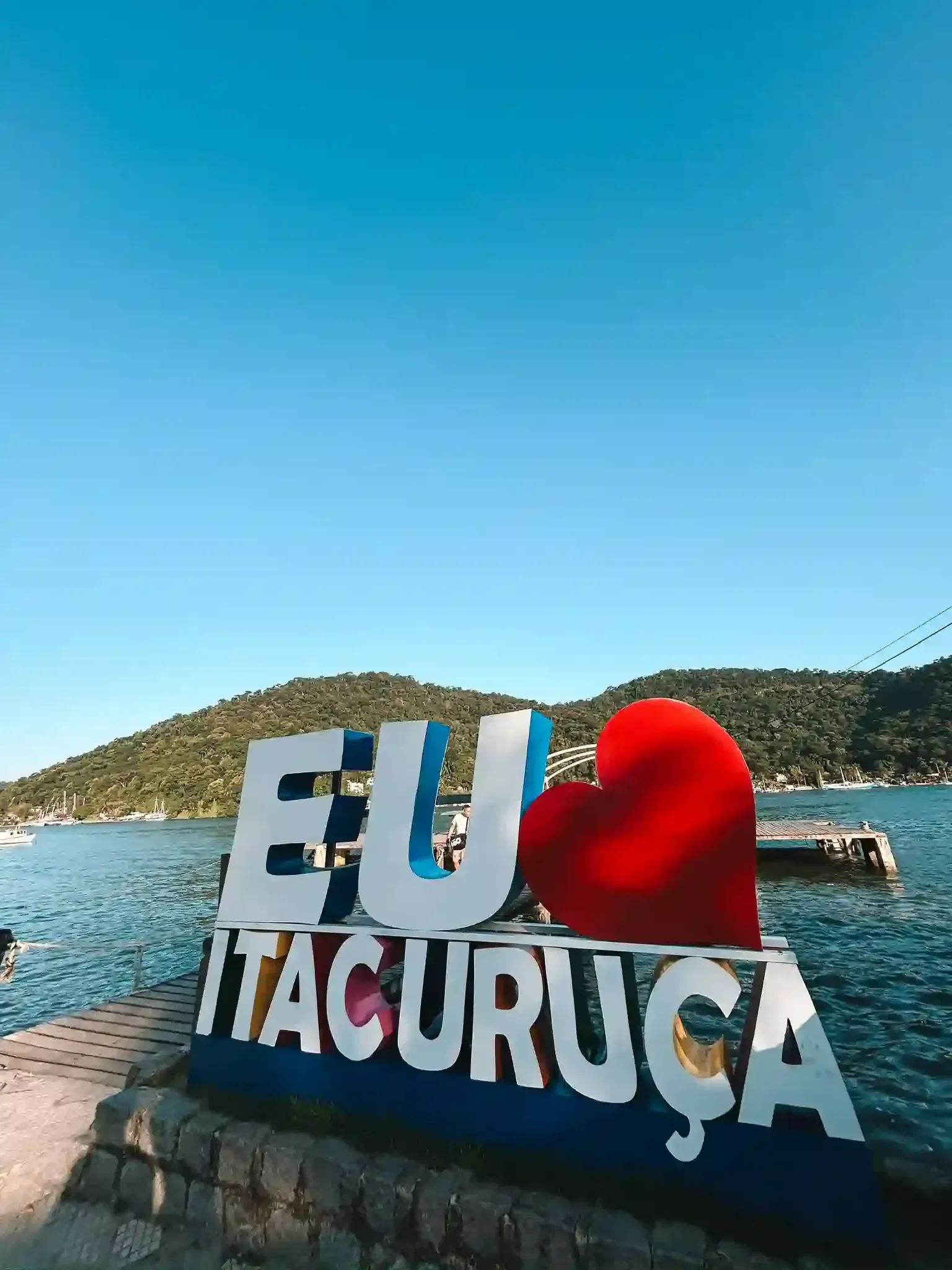 Uma placa que diz eu tacuruca com um coração vermelho na frente de um corpo d'água-pousada-itacuruca-inn