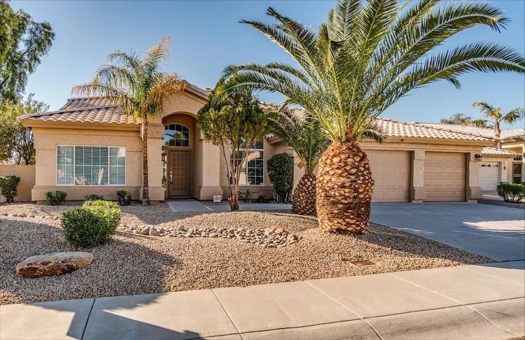 A large house with a palm tree in front of it.