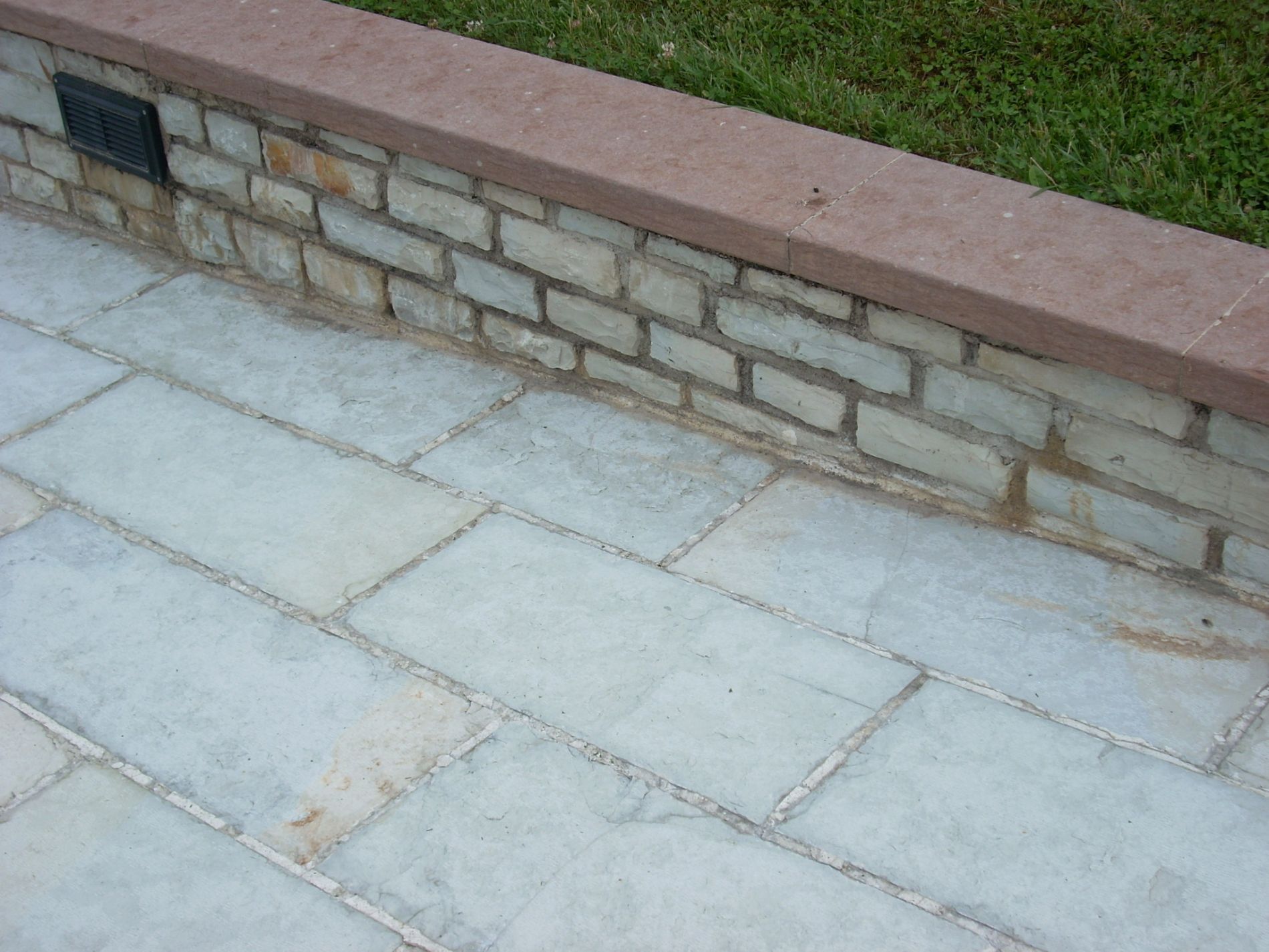 Pavimentazione in pietra naturale e muretto in pietra Rosso Secca