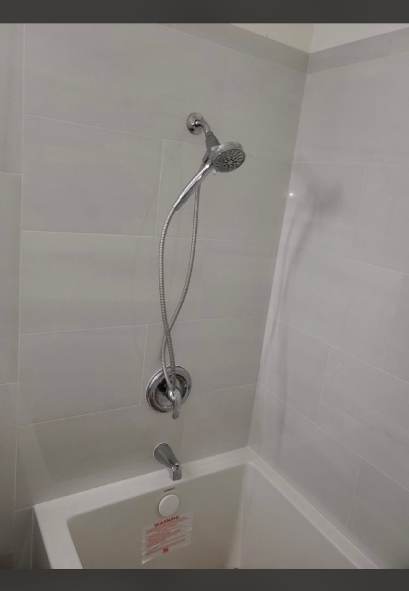a shower head is attached to a bathtub in a bathroom .