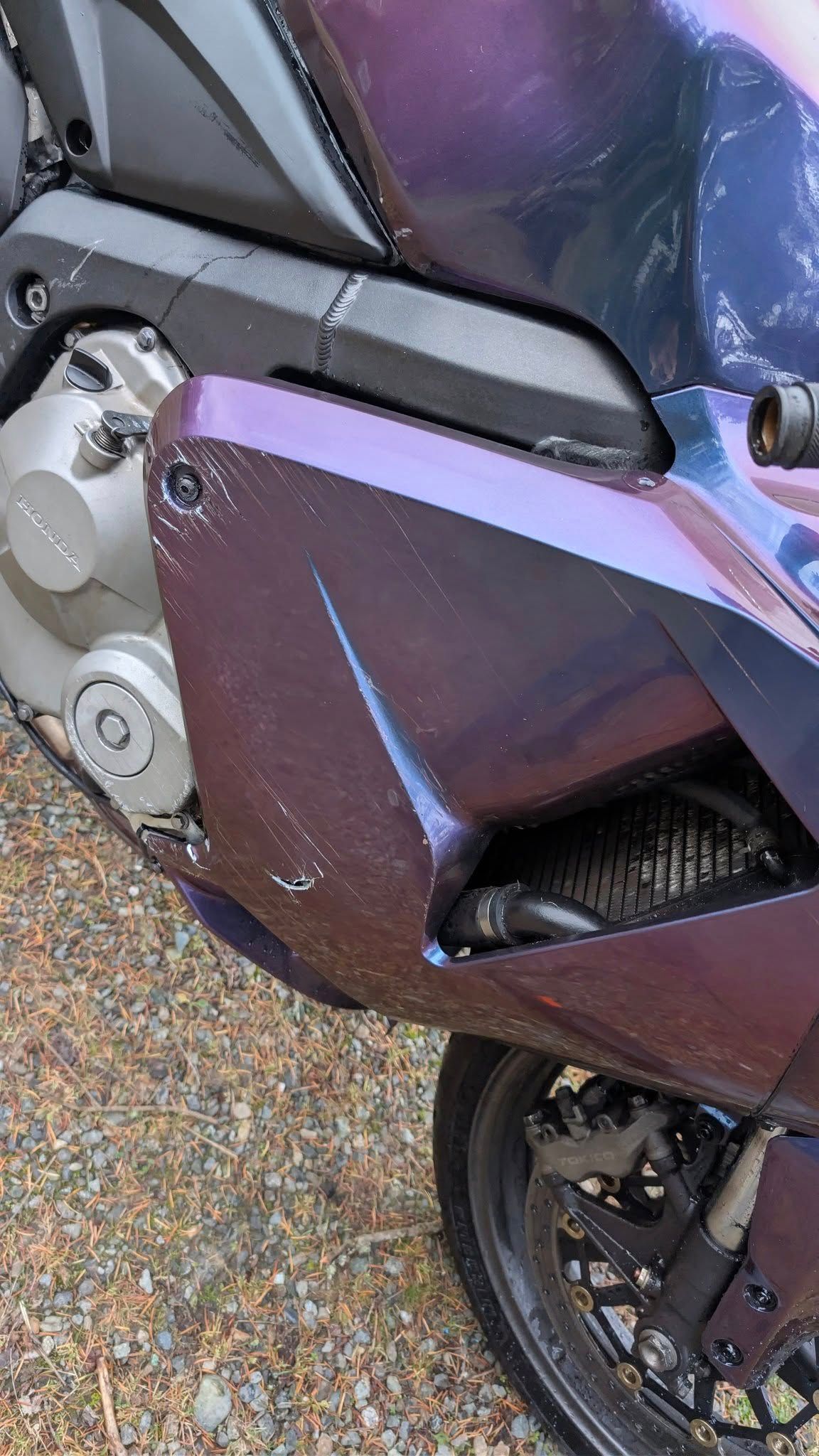 Woman in straw hat smiles, holding wine glass near a lake.