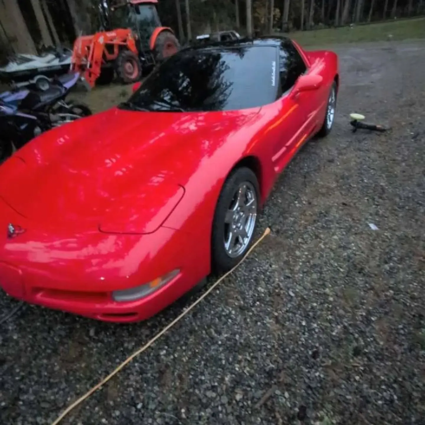 Woman in straw hat smiles, holding wine glass near a lake.