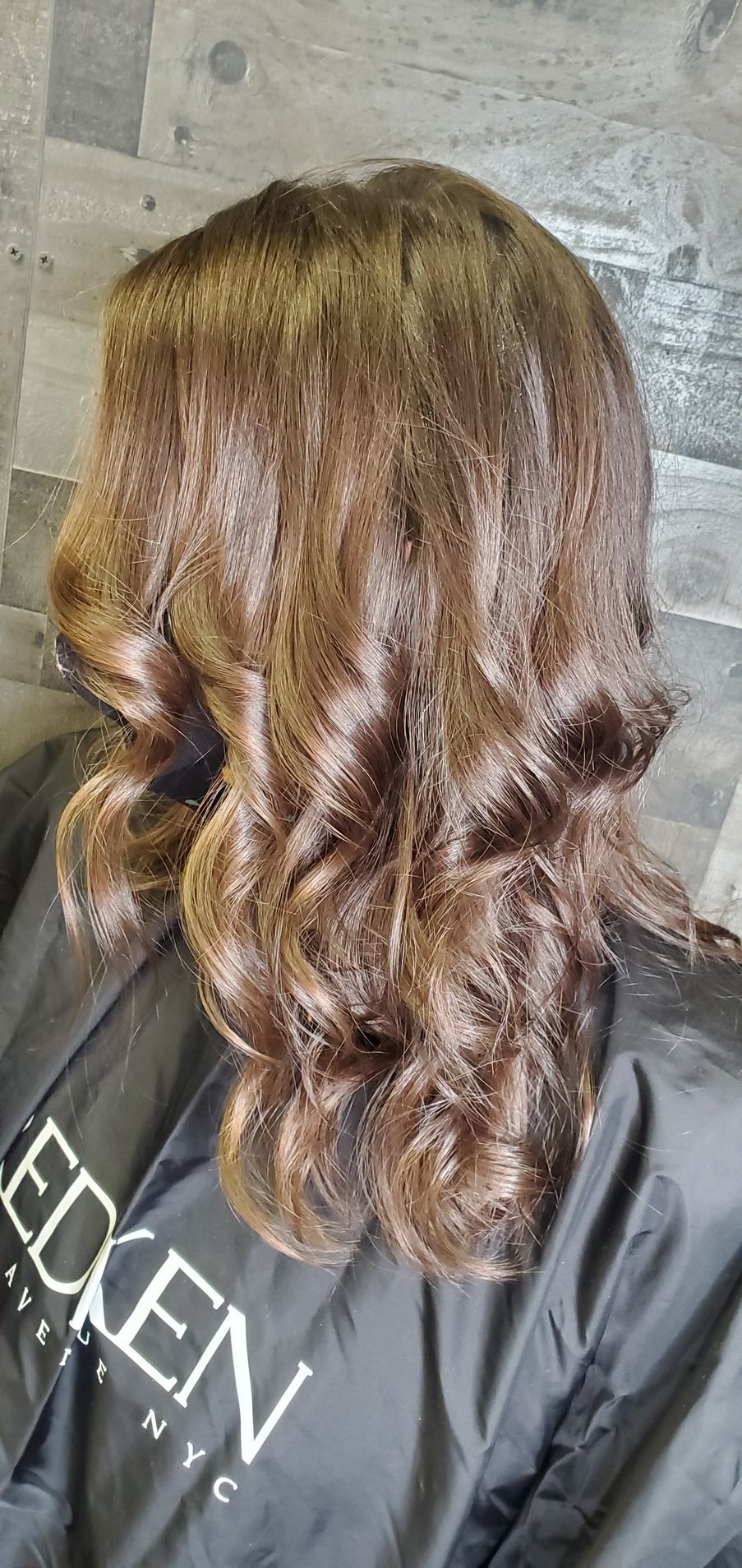A woman is sitting in a chair with her hair in a bun.
