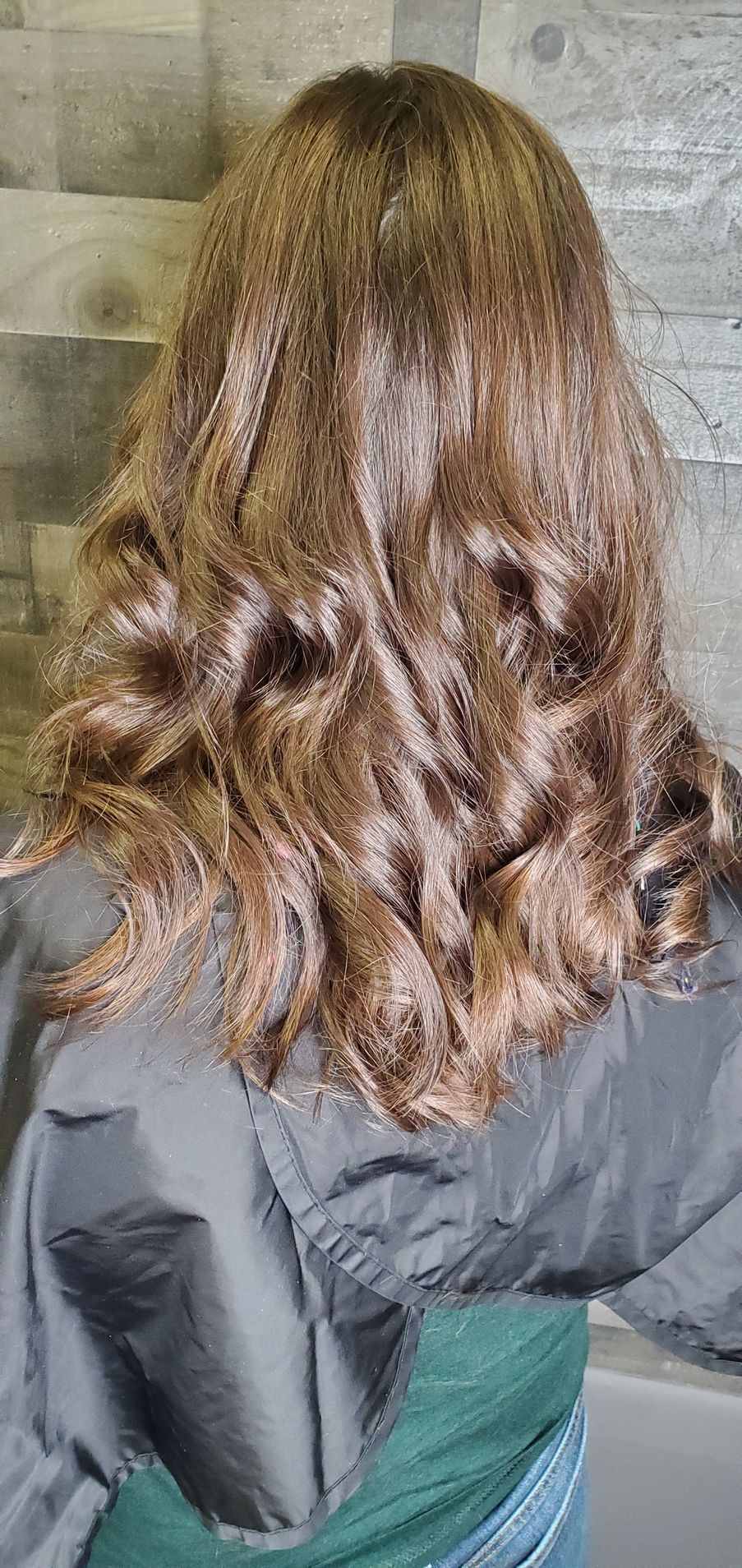 A woman with long brown hair is wearing a gray jacket.