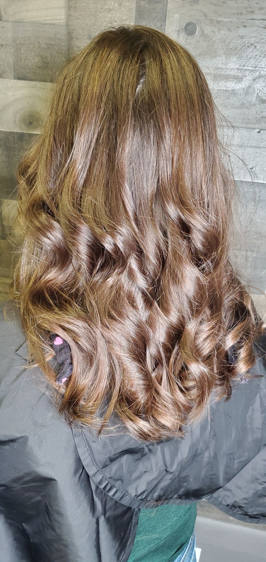 A woman with long brown hair is wearing a black jacket.