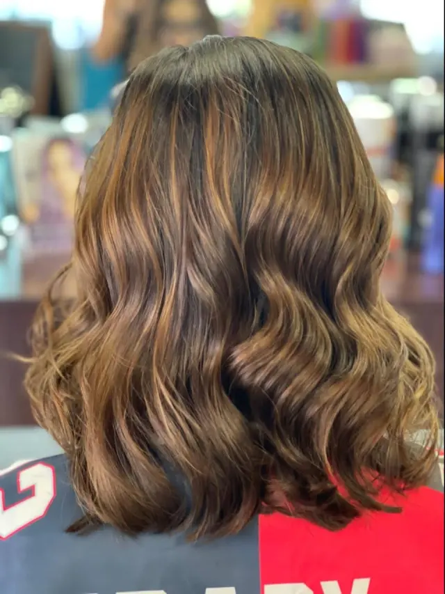 The back of a woman 's hair is shown in a salon.