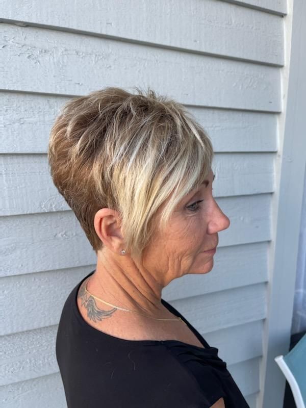 A woman with short blonde hair is wearing a black shirt